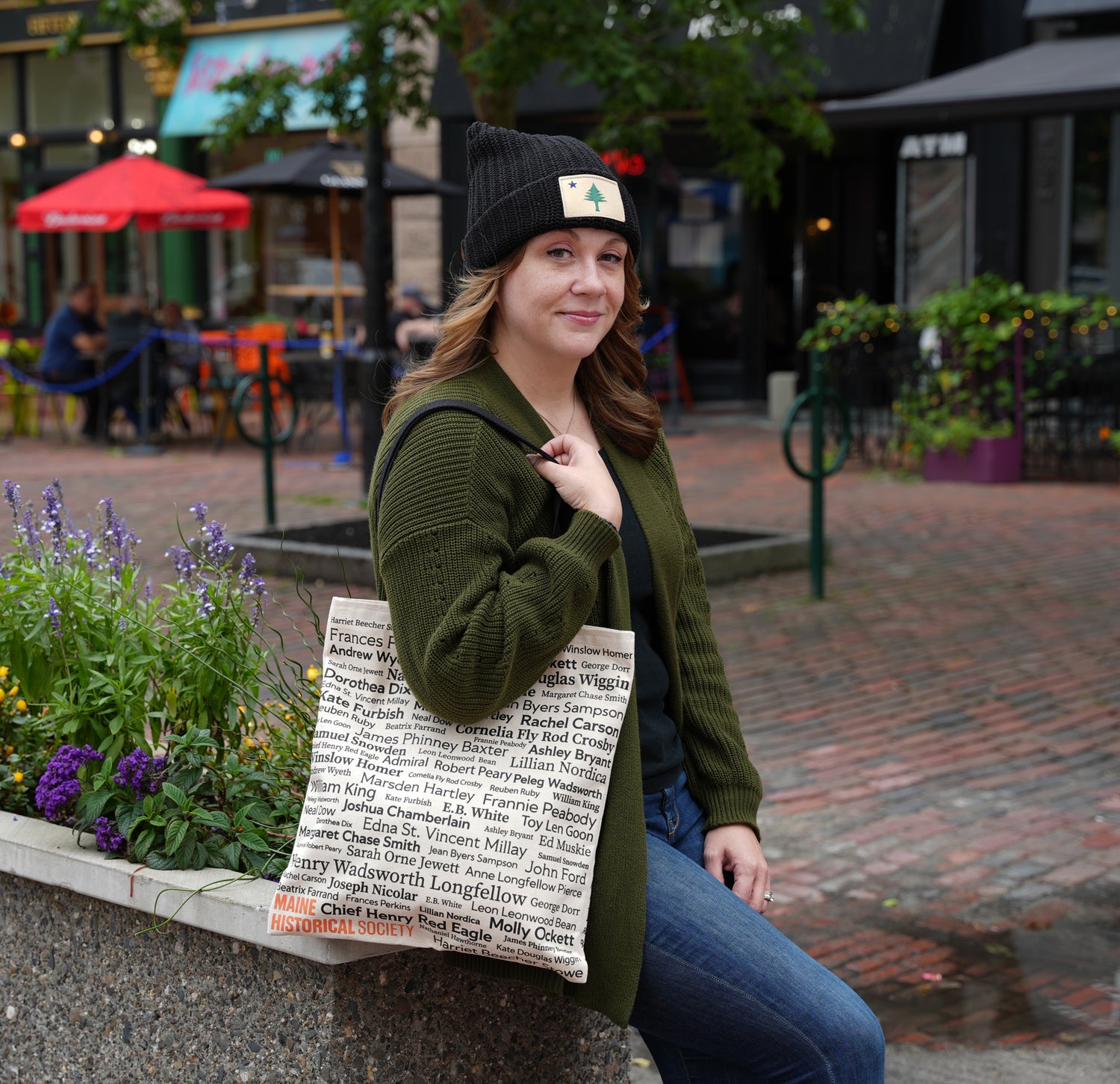 image of woman wearing Maine hat and carrying tote bag